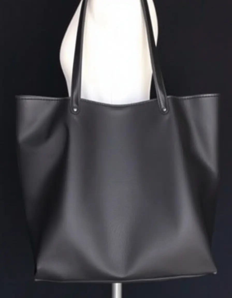A variety of elegant black leather purses on a wooden table