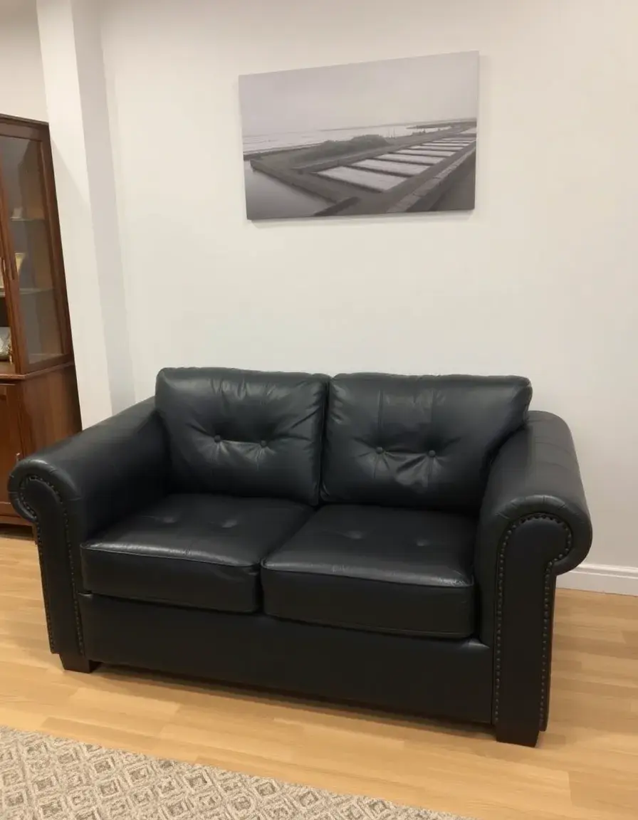 Black two-seater leather loveseat in a modern setting